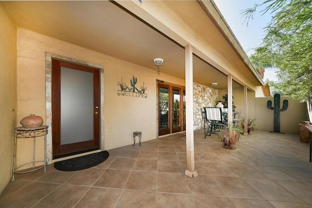 entrance to property featuring french doors and a patio area