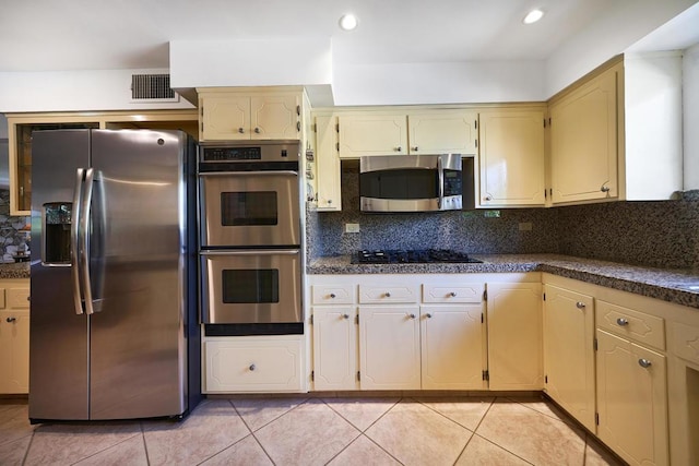 kitchen featuring decorative backsplash, light tile patterned flooring, and stainless steel appliances