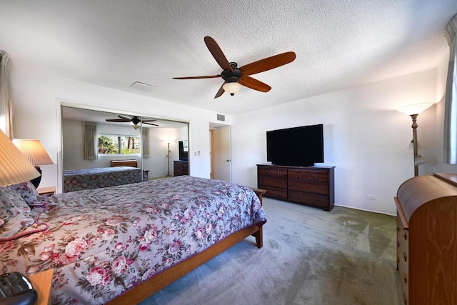 carpeted bedroom with a textured ceiling and ceiling fan