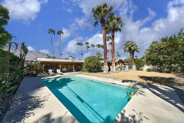 view of pool with a mountain view and a patio