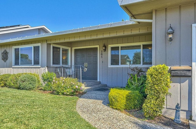 view of exterior entry with a lawn