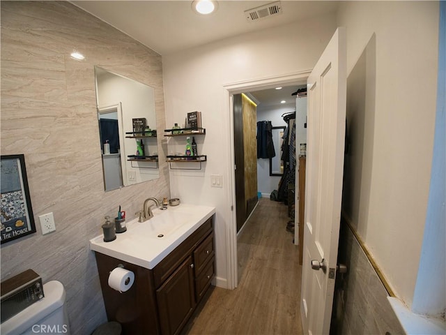 bathroom featuring visible vents, toilet, wood finished floors, vanity, and recessed lighting