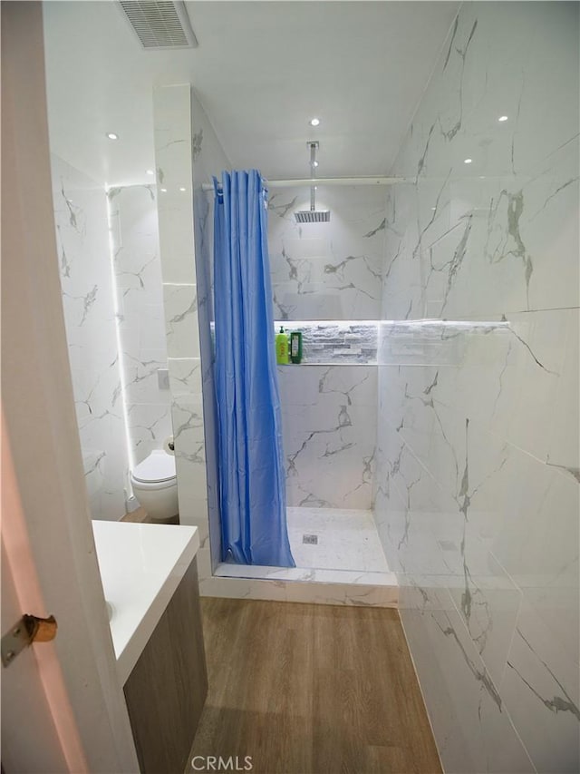 full bathroom featuring visible vents, toilet, a stall shower, vanity, and wood finished floors