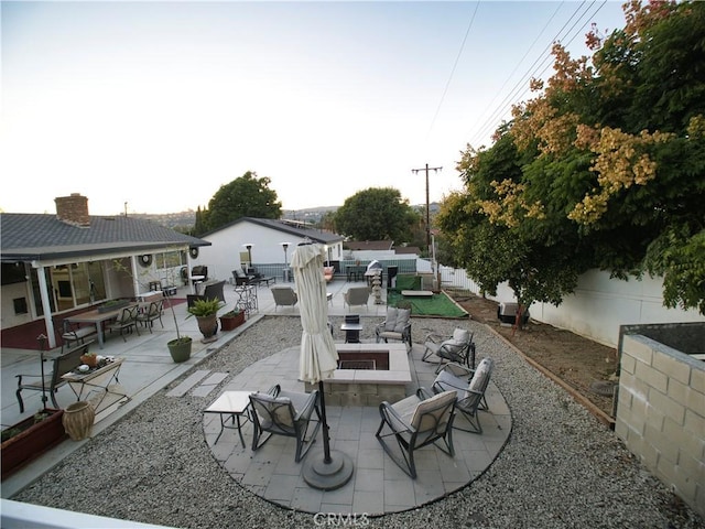 view of patio / terrace featuring an outdoor fire pit, exterior bar, and fence