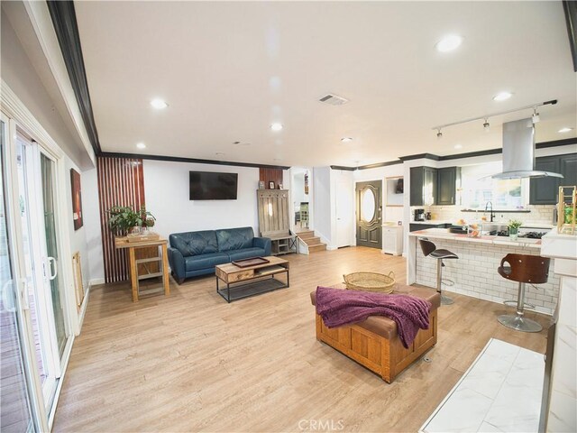 living area featuring visible vents, light wood-style flooring, stairs, crown molding, and recessed lighting