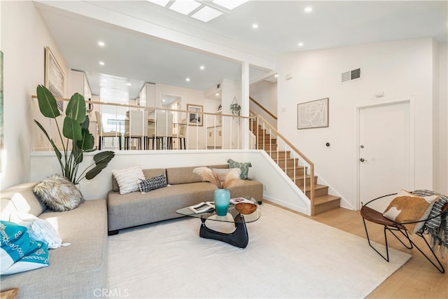 living room with light hardwood / wood-style floors and vaulted ceiling