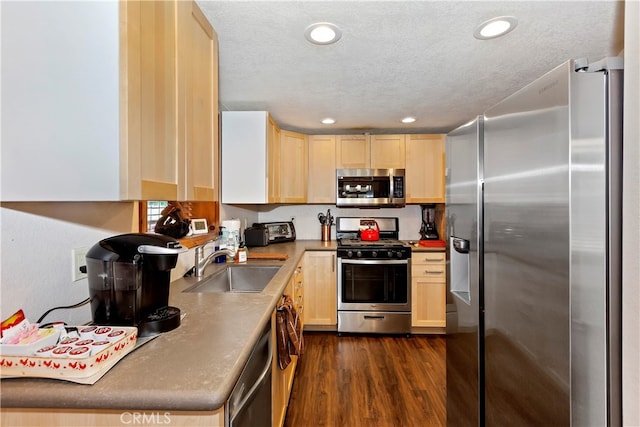 kitchen with sink, a textured ceiling, light brown cabinets, appliances with stainless steel finishes, and dark hardwood / wood-style flooring