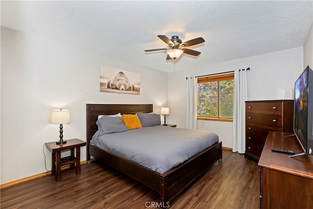 bedroom featuring dark wood-type flooring, ceiling fan, and a textured ceiling