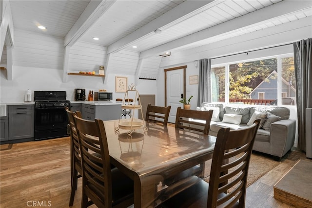 dining room featuring vaulted ceiling with beams, light hardwood / wood-style flooring, and wood ceiling