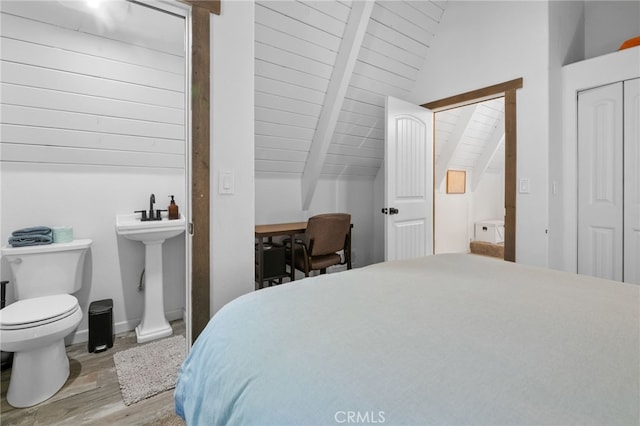 bedroom featuring light hardwood / wood-style floors, vaulted ceiling with beams, a closet, and wood ceiling