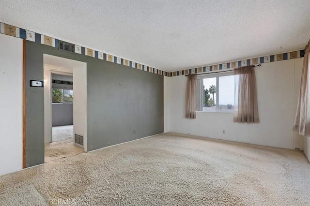 empty room featuring light carpet and a textured ceiling