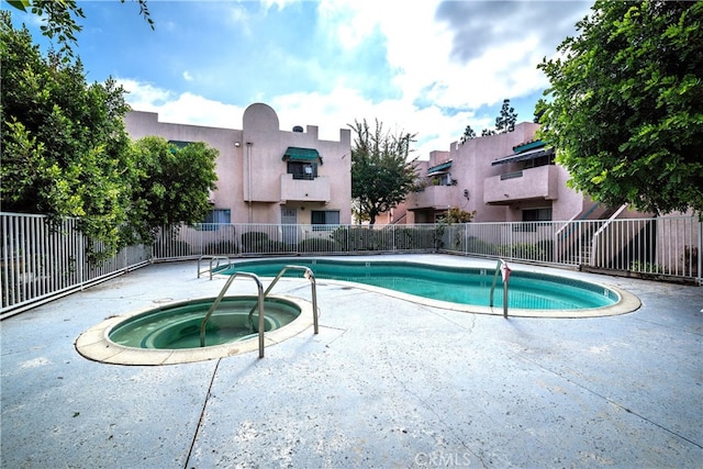 view of swimming pool with a hot tub