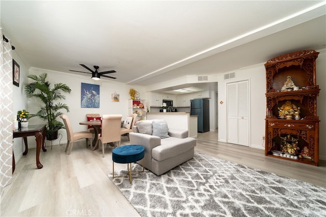 living room featuring crown molding, wood-type flooring, and ceiling fan