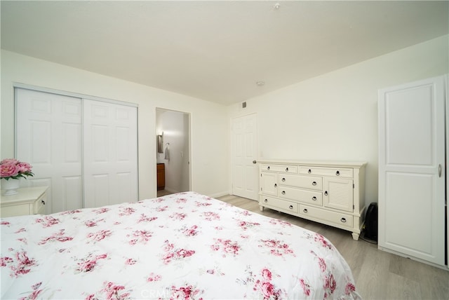 bedroom with light hardwood / wood-style flooring and a closet