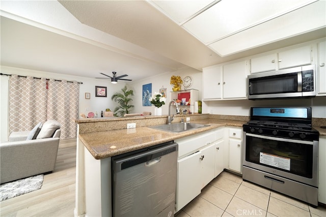 kitchen featuring sink, appliances with stainless steel finishes, kitchen peninsula, and white cabinets