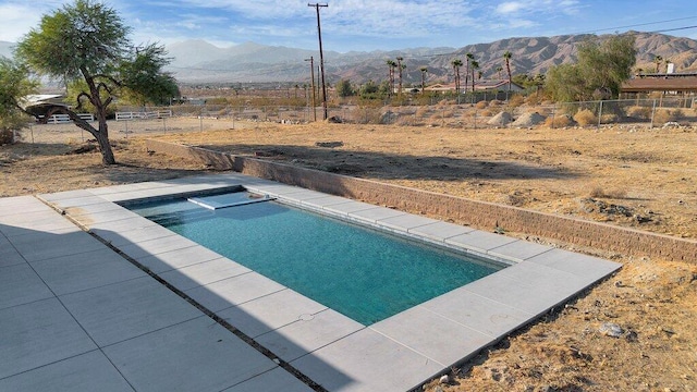 view of swimming pool with an in ground hot tub and a mountain view