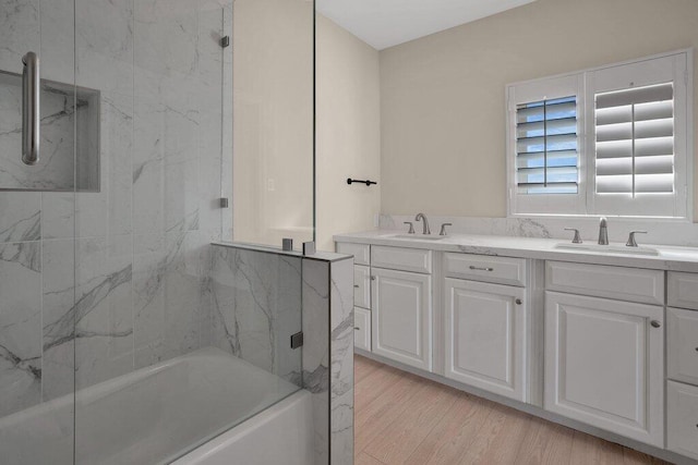 bathroom featuring vanity, enclosed tub / shower combo, and hardwood / wood-style flooring