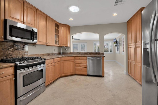 kitchen featuring sink, decorative backsplash, stainless steel appliances, and light tile patterned floors