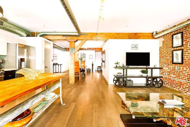 interior space featuring brick wall and hardwood / wood-style floors