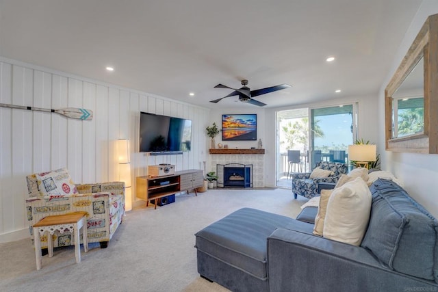 living room featuring wooden walls, light colored carpet, and ceiling fan