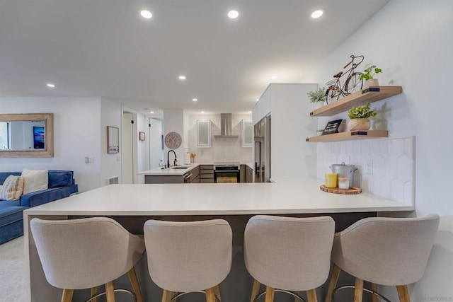 kitchen with white cabinets, kitchen peninsula, decorative backsplash, and stainless steel appliances