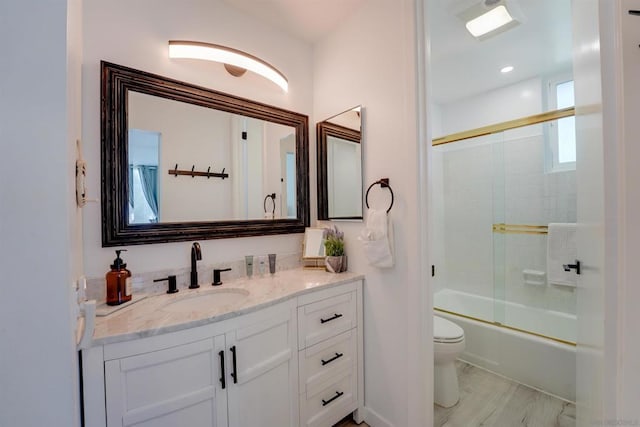 full bathroom featuring toilet, wood-type flooring, vanity, and shower / bath combination with glass door