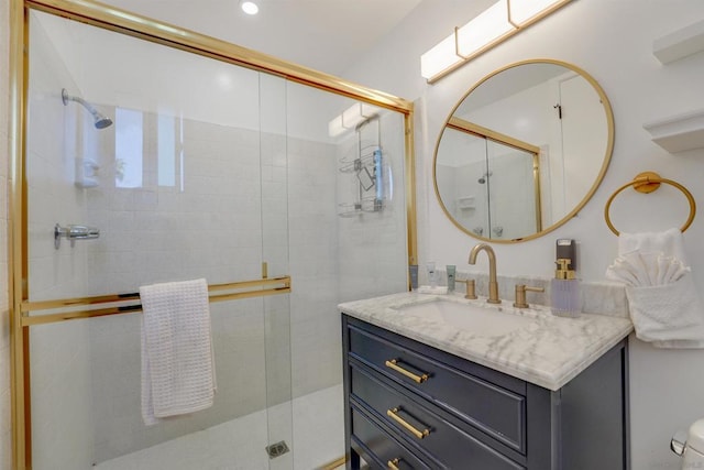 bathroom with a shower with shower door and vanity