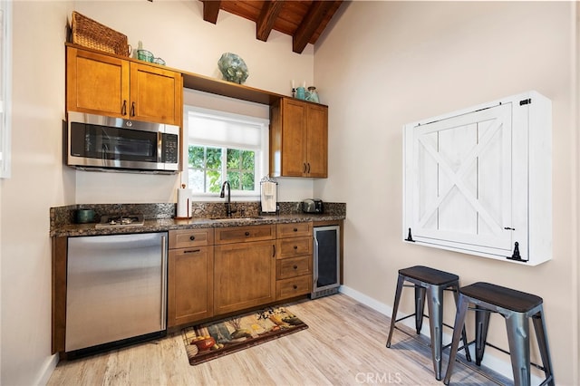 kitchen with sink, stainless steel appliances, beamed ceiling, wooden ceiling, and wine cooler