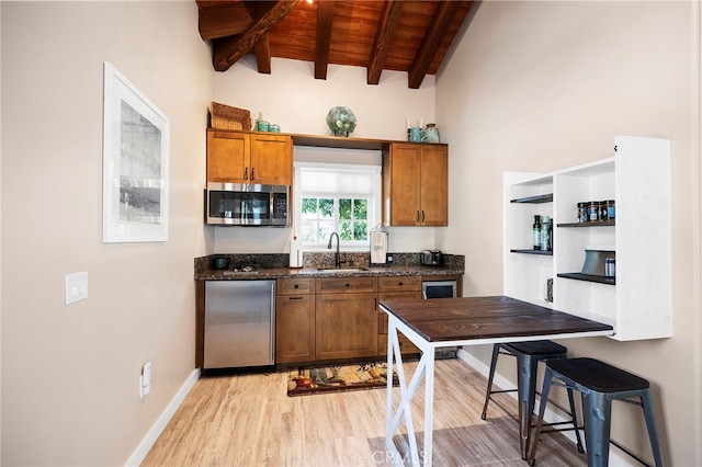 kitchen with wood ceiling, appliances with stainless steel finishes, light wood-type flooring, lofted ceiling with beams, and sink