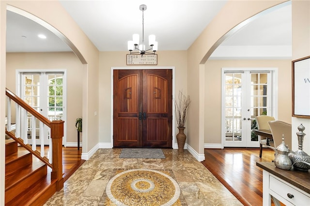 foyer entrance with french doors, a healthy amount of sunlight, and wood-type flooring