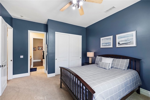 bedroom with a closet, ceiling fan, and light colored carpet