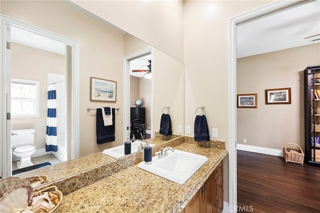 bathroom with toilet, hardwood / wood-style floors, and vanity