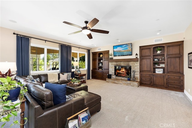 living room featuring light carpet, a fireplace, and ceiling fan