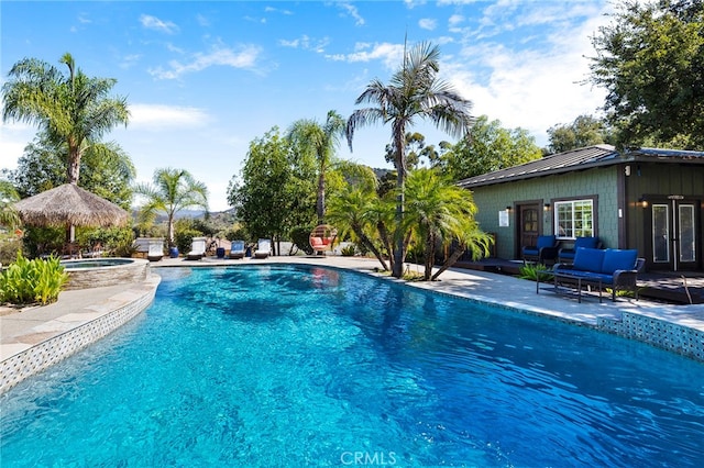 view of pool with a patio area and an in ground hot tub