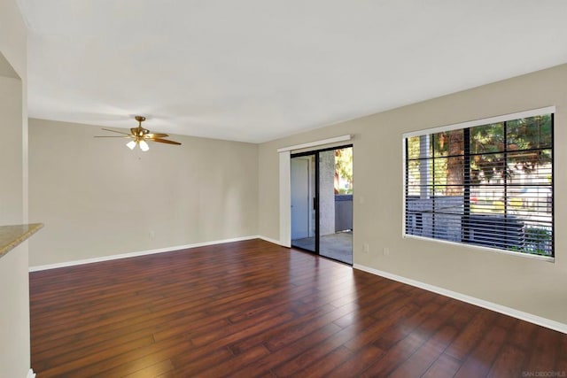 spare room with dark hardwood / wood-style floors and ceiling fan