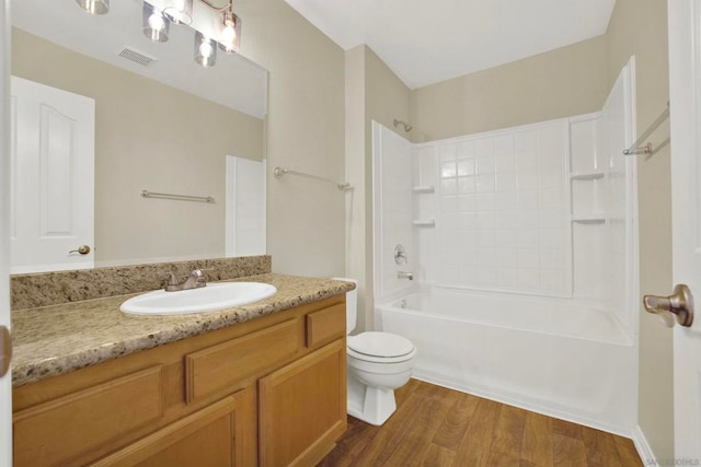 full bathroom with vanity, hardwood / wood-style floors, toilet, and shower / bathtub combination