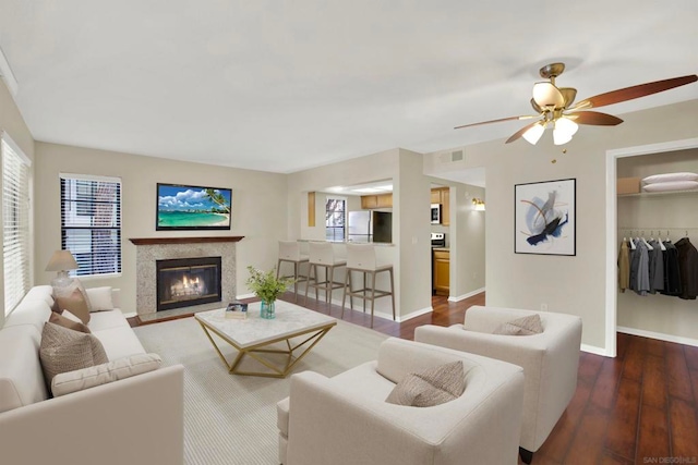 living room with ceiling fan and dark hardwood / wood-style flooring