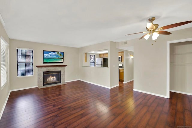 unfurnished living room featuring dark hardwood / wood-style floors and ceiling fan