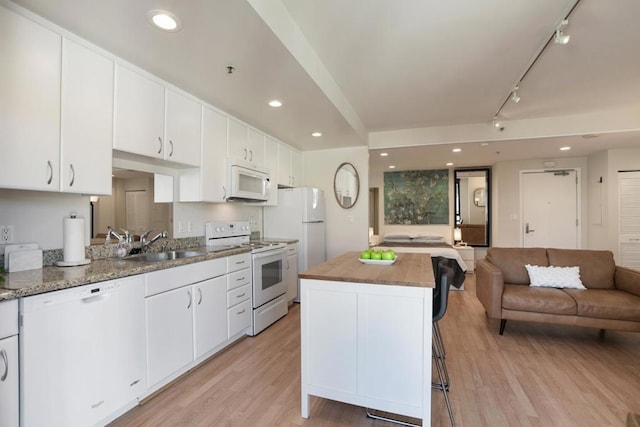 kitchen featuring white cabinetry, sink, light hardwood / wood-style floors, and white appliances