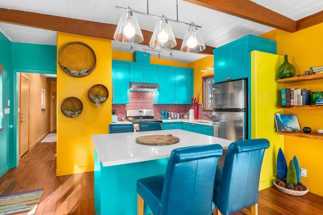 kitchen featuring beamed ceiling, stainless steel appliances, a center island, blue cabinets, and dark hardwood / wood-style flooring