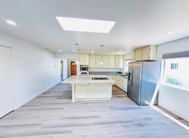 kitchen featuring light hardwood / wood-style floors, appliances with stainless steel finishes, a center island, and pendant lighting