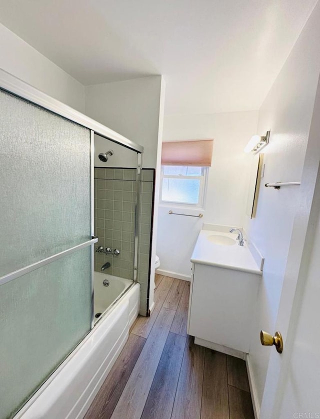 full bathroom featuring vanity, toilet, shower / bath combination with glass door, and hardwood / wood-style floors