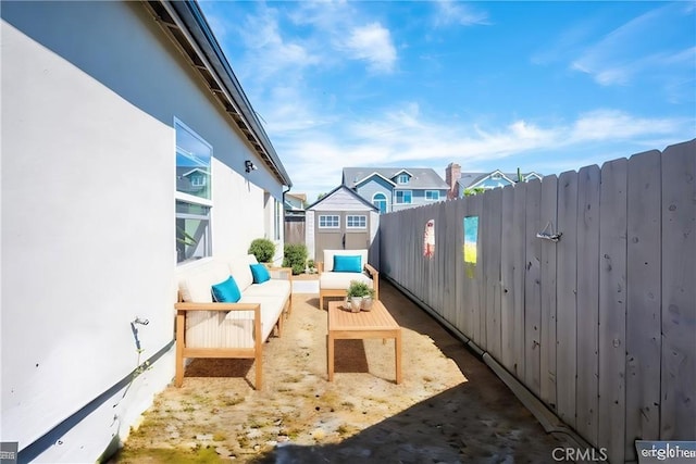 view of patio with a storage shed, fence, an outdoor living space, and an outdoor structure