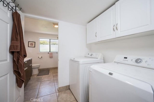 laundry room with washing machine and dryer, baseboards, and light tile patterned floors