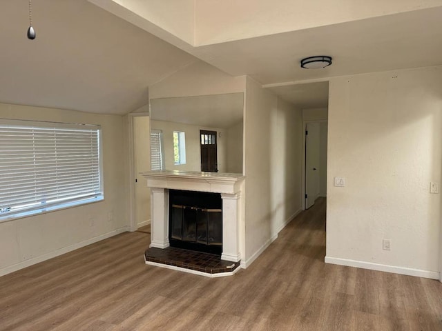 unfurnished living room featuring wood-type flooring and vaulted ceiling