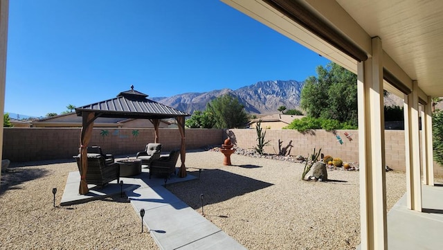 view of patio featuring a gazebo, an outdoor living space, and a mountain view