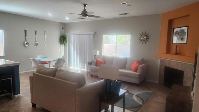 living room featuring tile patterned floors, a tile fireplace, and ceiling fan