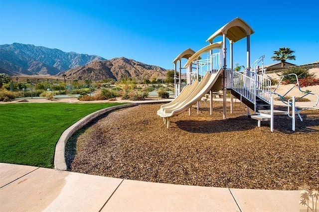 view of jungle gym with a yard and a mountain view