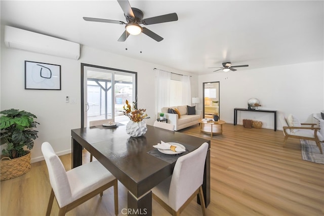 dining area featuring an AC wall unit, wood-type flooring, and ceiling fan