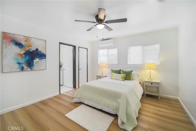 bedroom featuring ceiling fan, a wall unit AC, and hardwood / wood-style floors